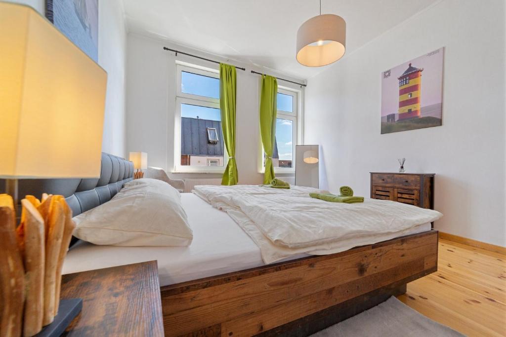 a bedroom with a large bed with green curtains at Infinity Stay: Bis zu 6 Personen Zentrumsnah Wassernah Netflix in Wilhelmshaven