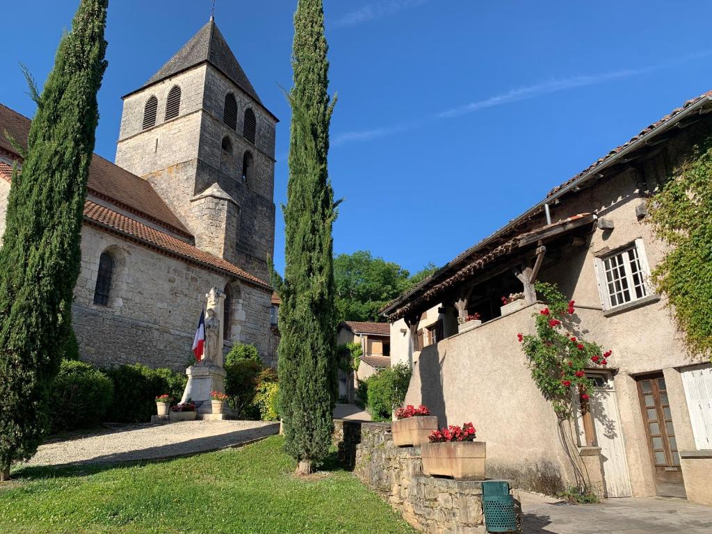 a building with a tower and a church at stylish one bedroom apartment in a lovely village in Saint-Vincent-Rive-dʼOlt