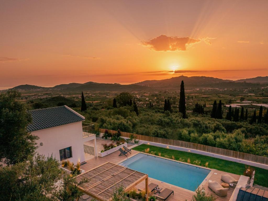 a villa with a swimming pool at sunset at Villa Verde in Kallithea