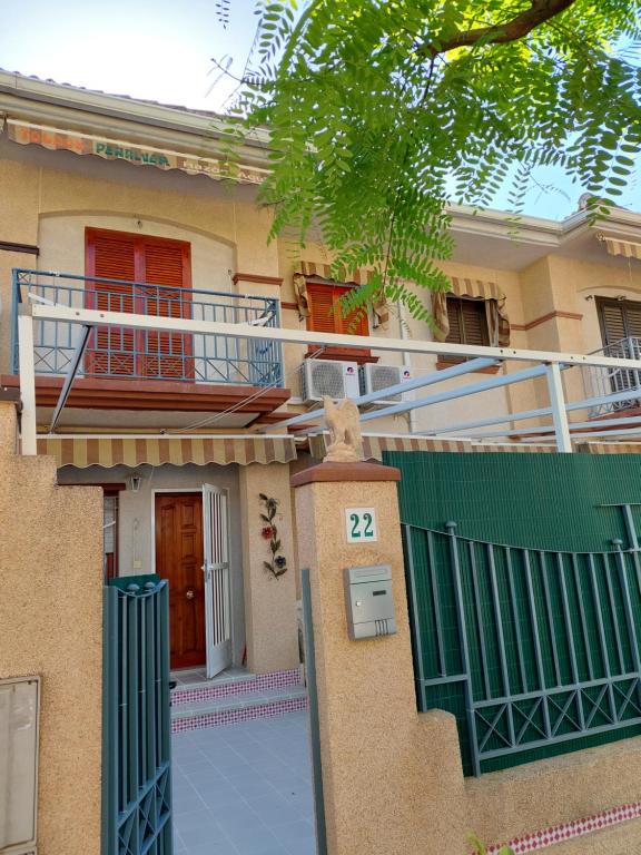 a house with a gate and a balcony on it at Casa Valentino in Santa Pola
