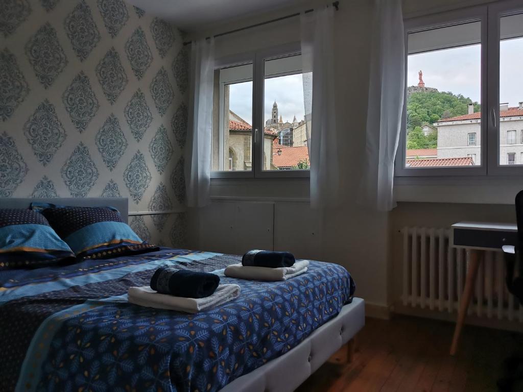 um quarto com uma cama com duas toalhas em Velay cocon appartement 4 chambres avec vue sur les monuments em Le Puy-en-Velay