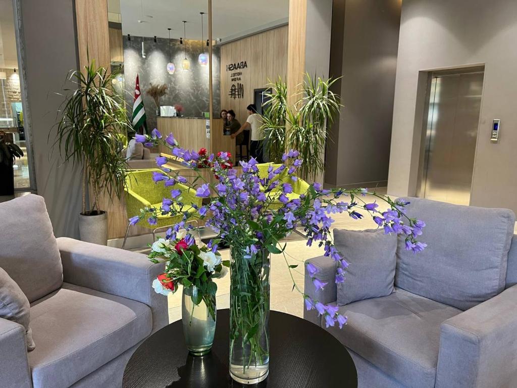 un jarrón de flores sobre una mesa en una tienda en Abaash Hotel Afon, en Novi Afon