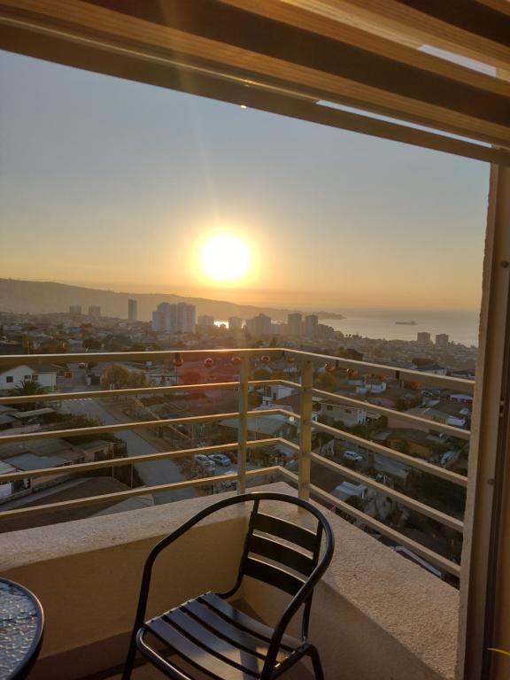 瓦爾帕萊索的住宿－Hermoso departamento Cerro los placeres Valparaíso，阳台的椅子,享有日落美景
