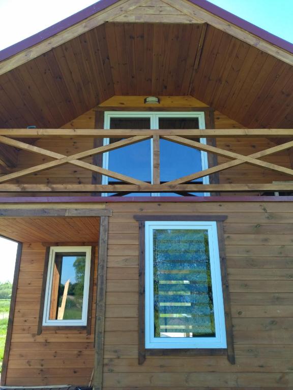 widok na przednią część domu z oknami w obiekcie Domki Jastrzębia Mazury w Pasymiu
