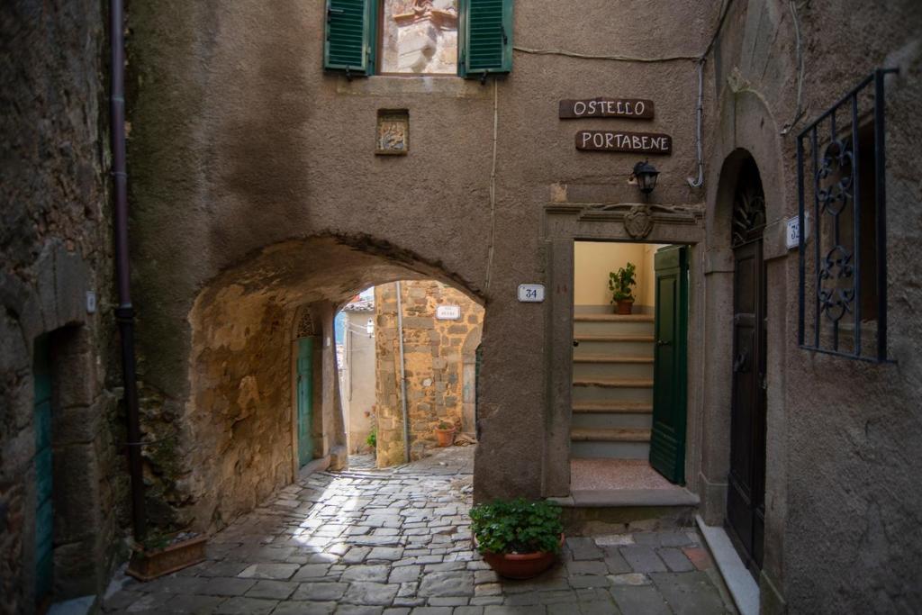 un callejón con un arco en un edificio antiguo en Ostello Portabene, en Montelaterone