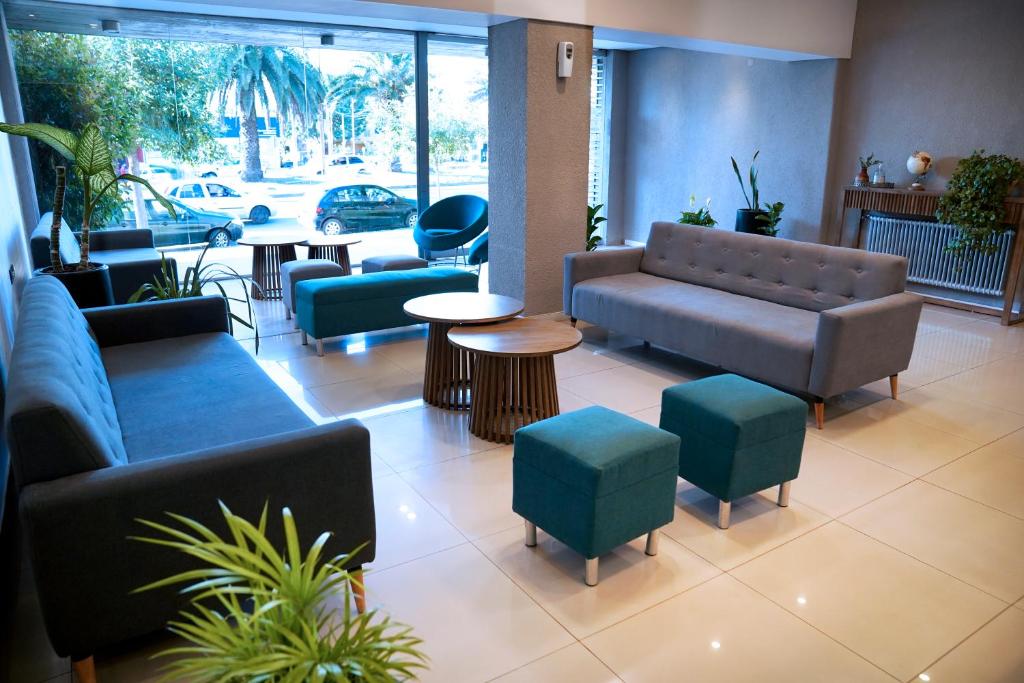 hol z kanapami, krzesłami i stołem w obiekcie Hotel Alpre w mieście Villa Carlos Paz