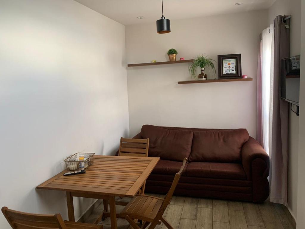 ein Wohnzimmer mit einem Sofa und einem Tisch in der Unterkunft Zona nuevo CAMPUS Universidad departamento independiente in Chihuahua
