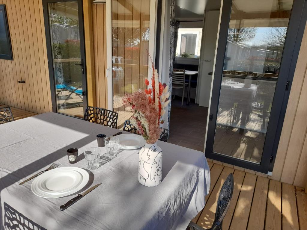 una mesa con un plato blanco encima en mobil home neuf dans camping 4* avec piscine en La Plaine-sur-Mer