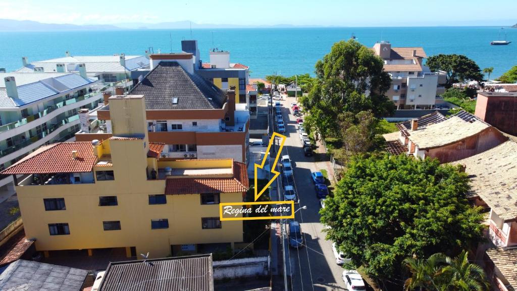 una calle de la ciudad con un letrero de la calle y el océano en Regina Del Mare Residence Apartamentos completos para até 05 pessoas a 50 metros da praia, en Florianópolis