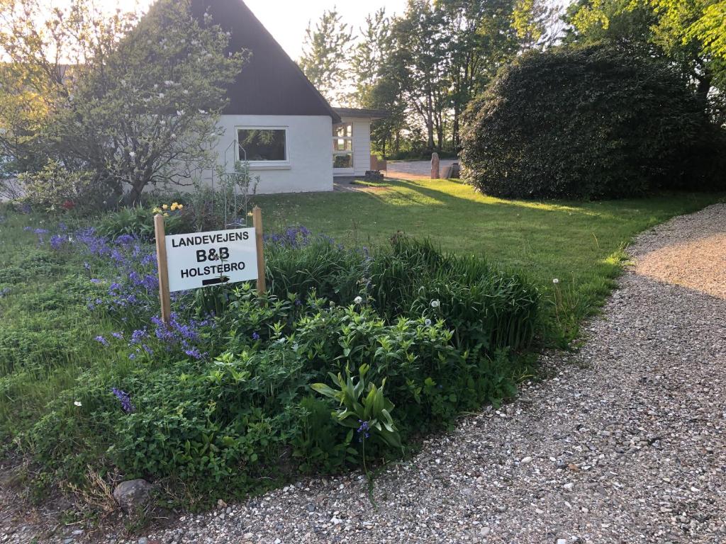 una señal frente a una casa con un patio en Landevejens B&B Holstebro en Holstebro