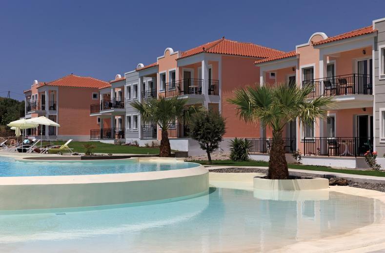 una piscina con palmeras frente a las casas en Eriphilly Studios & Apartments, en Mithimna