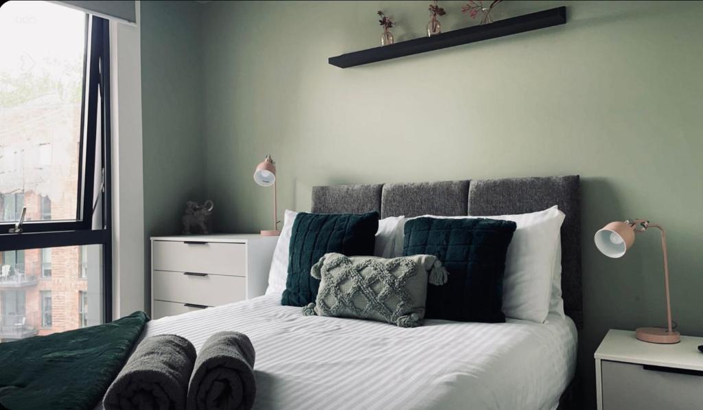 a bedroom with a bed with green and white pillows at Kelham-Gem in Sheffield