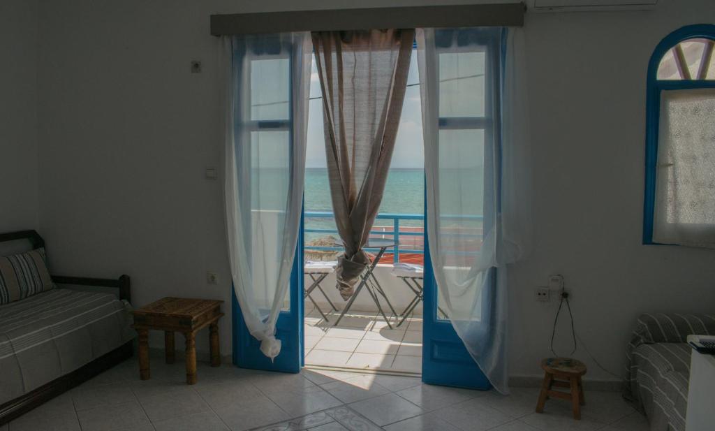uma sala de estar com uma janela com vista para o oceano em SOLE E MARE em Elafonisos