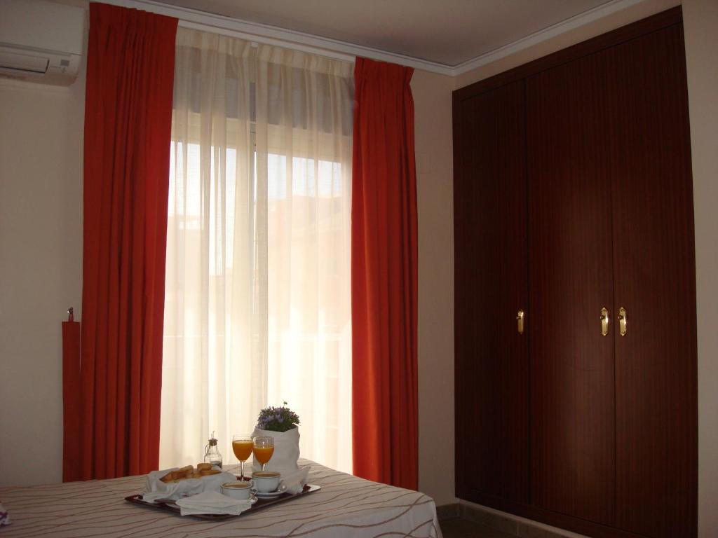 una habitación con una mesa con copas de vino y una ventana en Hotel Fin De Semana, en Gandía