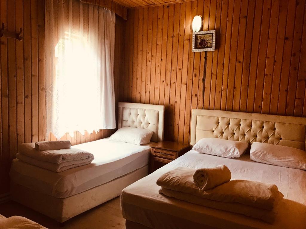 1 dormitorio con 2 camas y ventana en Uğur Motel, en Uzungöl