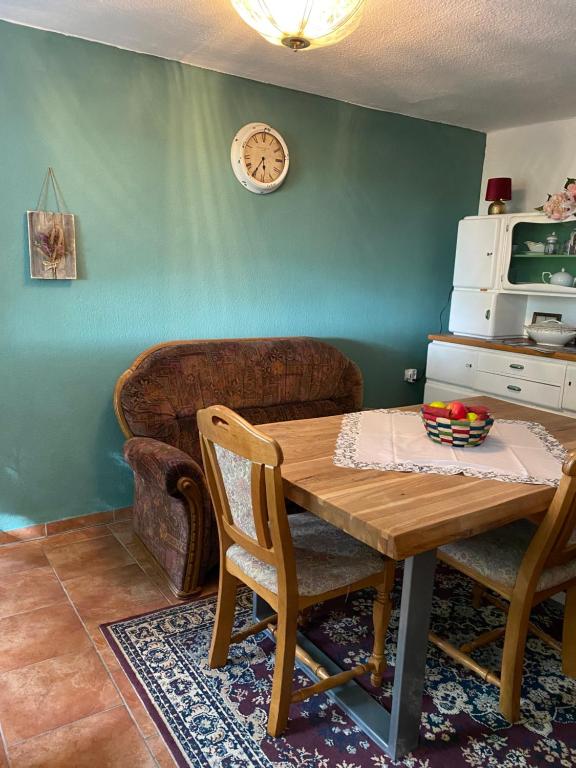 a living room with a wooden table and a couch at FeWo Unner'd Kastanje in Moormerland