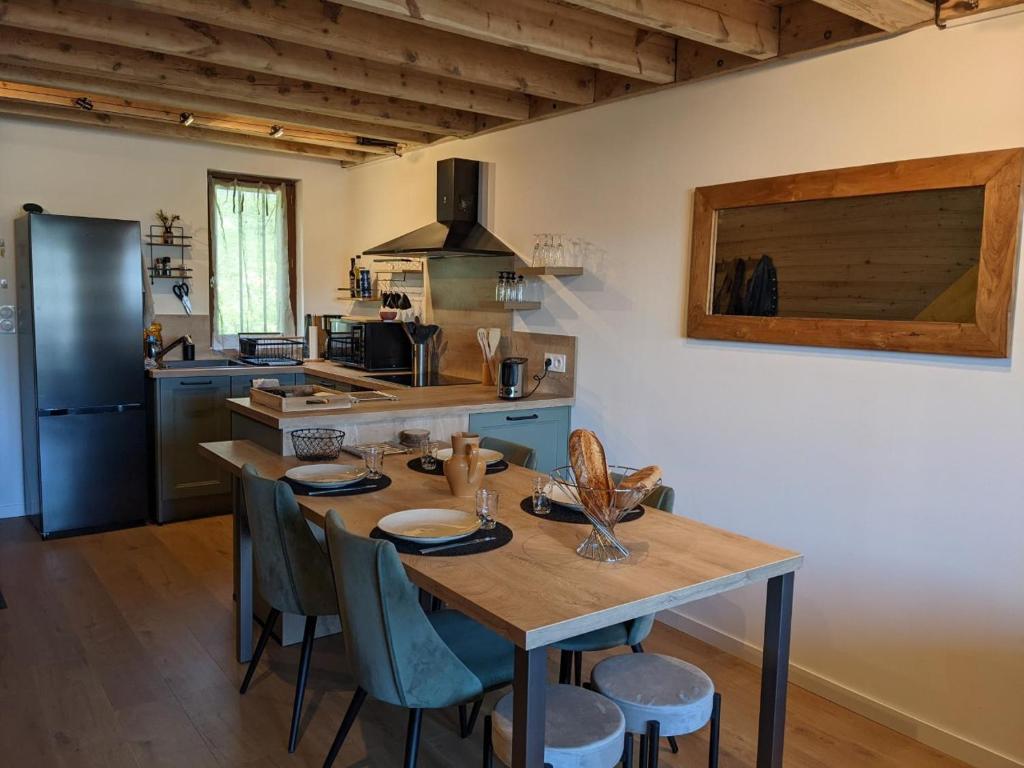 uma cozinha com uma mesa com cadeiras e um frigorífico em Appartemment type chalet em Formiguères