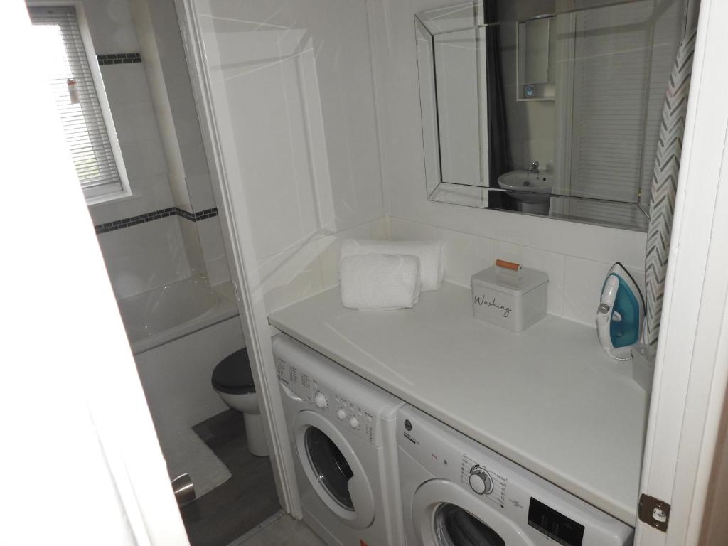 a bathroom with a washing machine and a sink at Serviced Accommodation in Hull