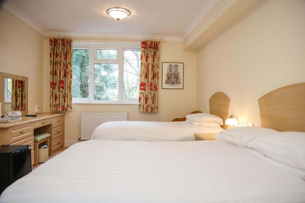 a bedroom with two beds and a window at The Grove Hotel in Bournemouth