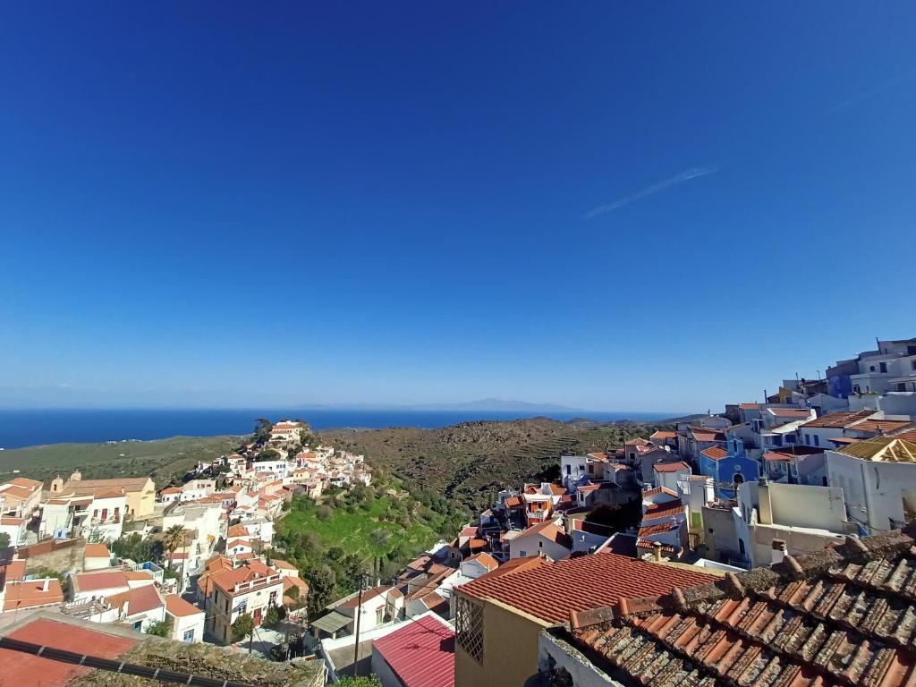 - une vue sur la ville avec ses bâtiments bleus et l'océan dans l'établissement Στη Μεσσάδα... Sti Messada..., à Ioulída