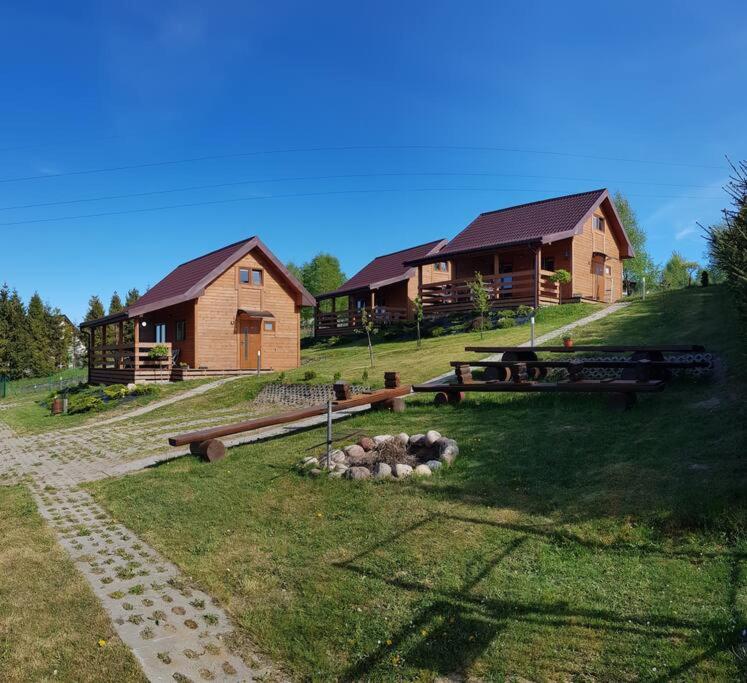 een groep stammen in een veld naast gebouwen bij CLAUDIA Domek na Kaszubach in Sławki