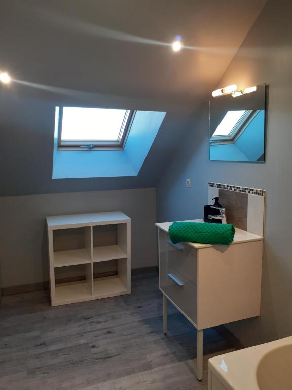 a room with two skylights and a sink and a mirror at Le Rêve de Marcel in Le Molay-Littry