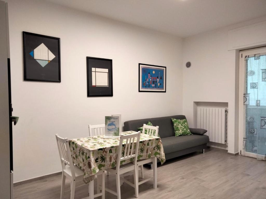 un soggiorno con divano, tavolo e sedie di appartamento fronte mare a Pescara