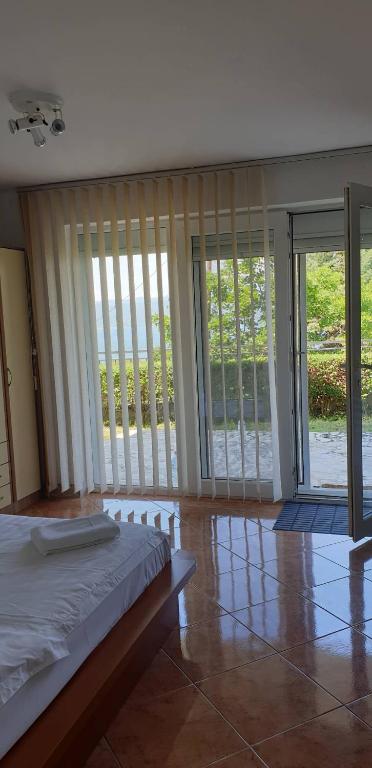 a bedroom with a bed and sliding glass doors at Apartman No 1 in Sretenovo