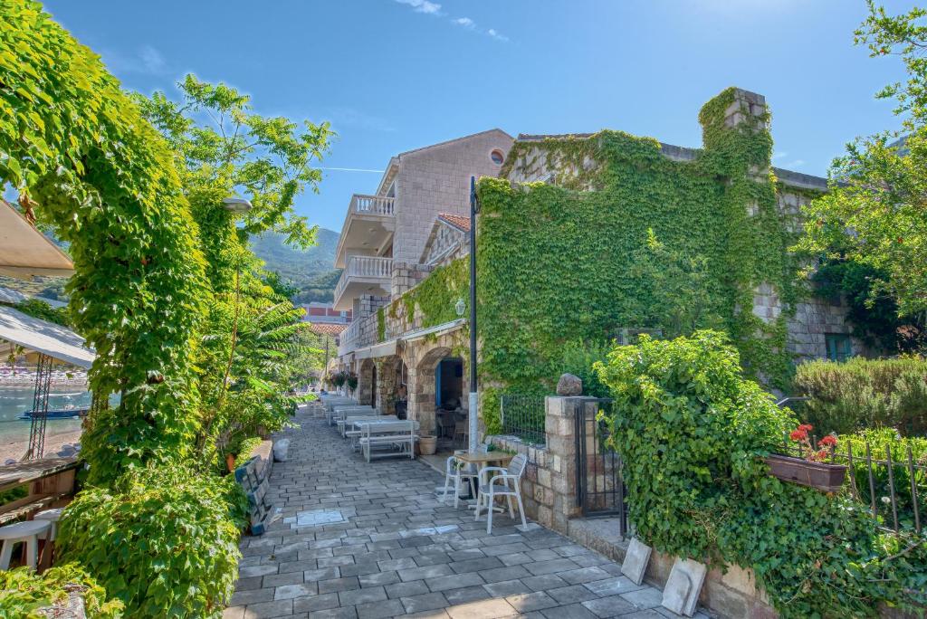 an alley with ivy on a building at Kazanegra Exclusive Apartments in Sveti Stefan