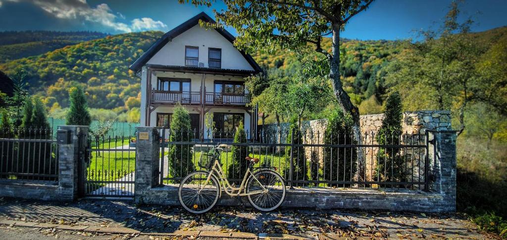 ein Fahrrad, das vor einem Zaun vor einem Haus geparkt ist in der Unterkunft Villa Vrelo Bosne in Sarajevo