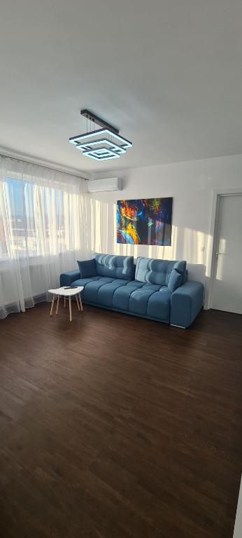 - un salon avec un canapé bleu et une table dans l'établissement Belvedere Delux Apartment, à Deva