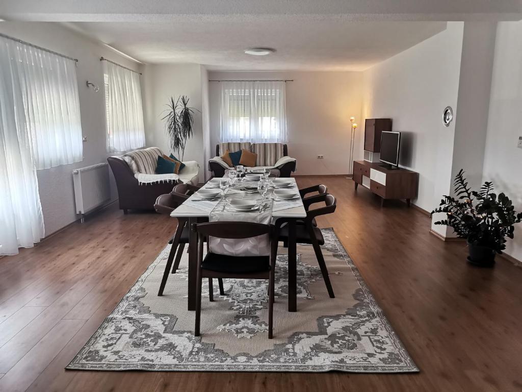 een eetkamer en woonkamer met een tafel en stoelen bij Apartman Sali in Bihać