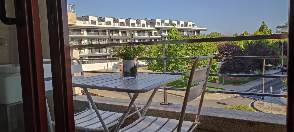 una mesa y 2 sillas en un balcón con un edificio en Zárate 3G, en Portonovo