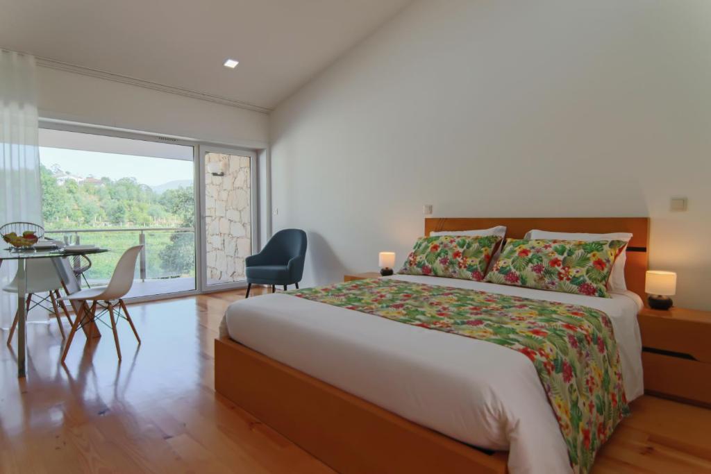 ein Schlafzimmer mit einem Bett und einem großen Fenster in der Unterkunft Varandas de S. Jorge - Apartments in Arcos de Valdevez