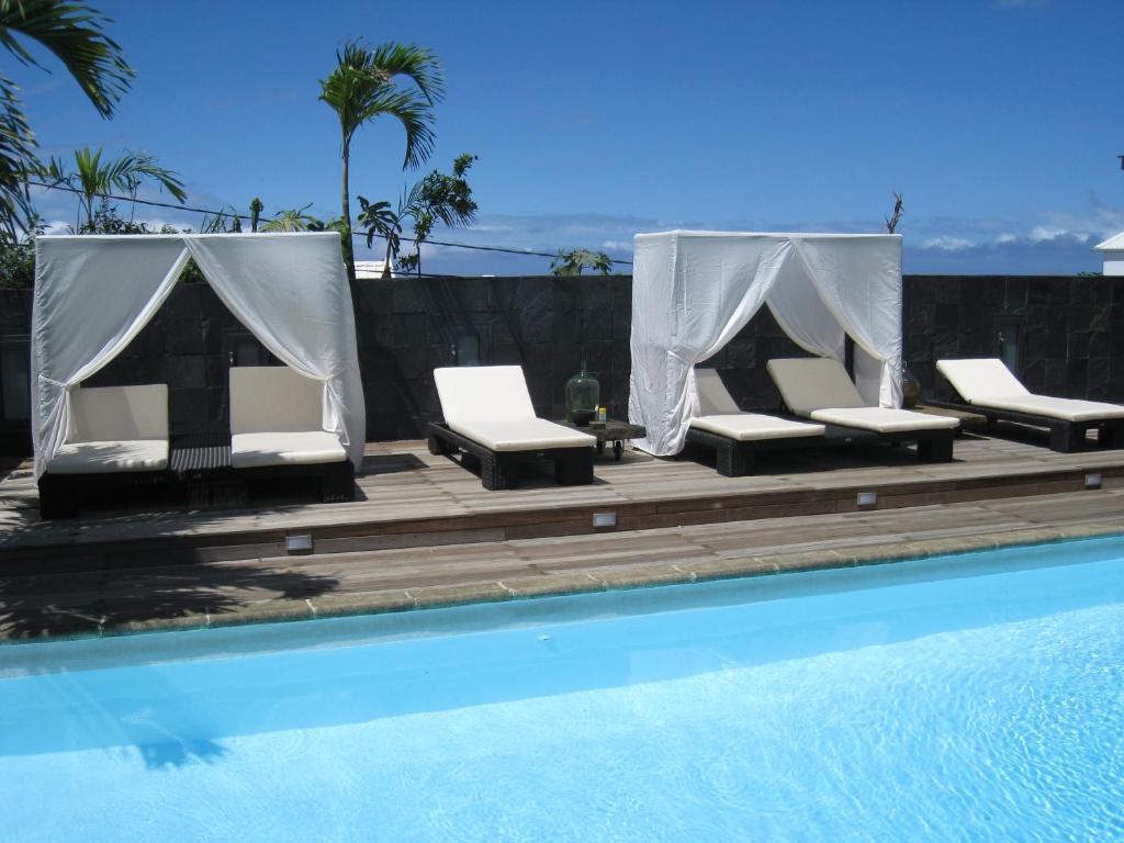 - une piscine avec 2 chaises longues à côté de la piscine dans l'établissement Villa Belle, à Saint-Pierre