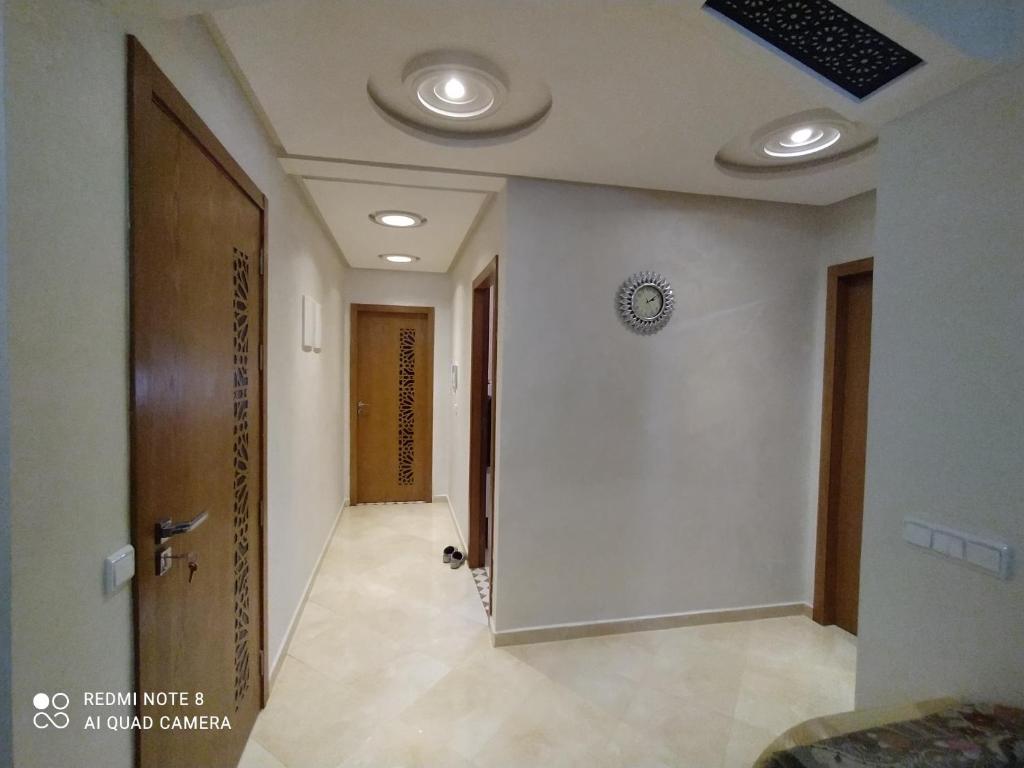 a hallway of a building with a door and lights at Appartement à Bouznika prêt du plage Dahomey, plage bouznika, Bahia beach in Bouznika