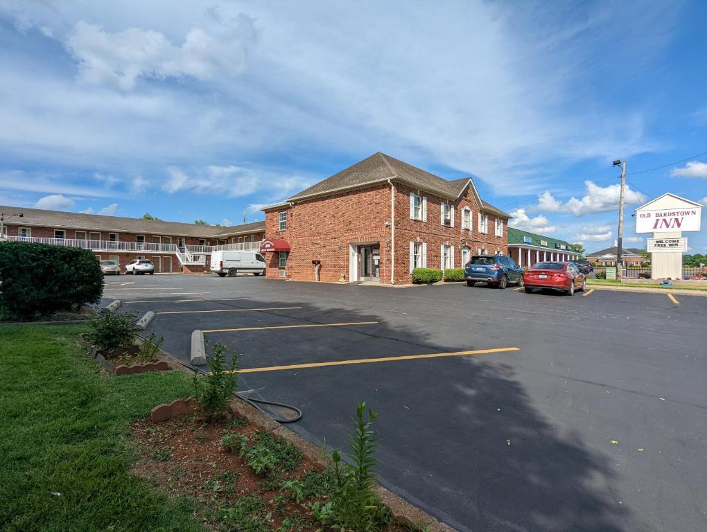 ein Parkplatz vor einem Backsteingebäude in der Unterkunft Old Bardstown Inn in Bardstown