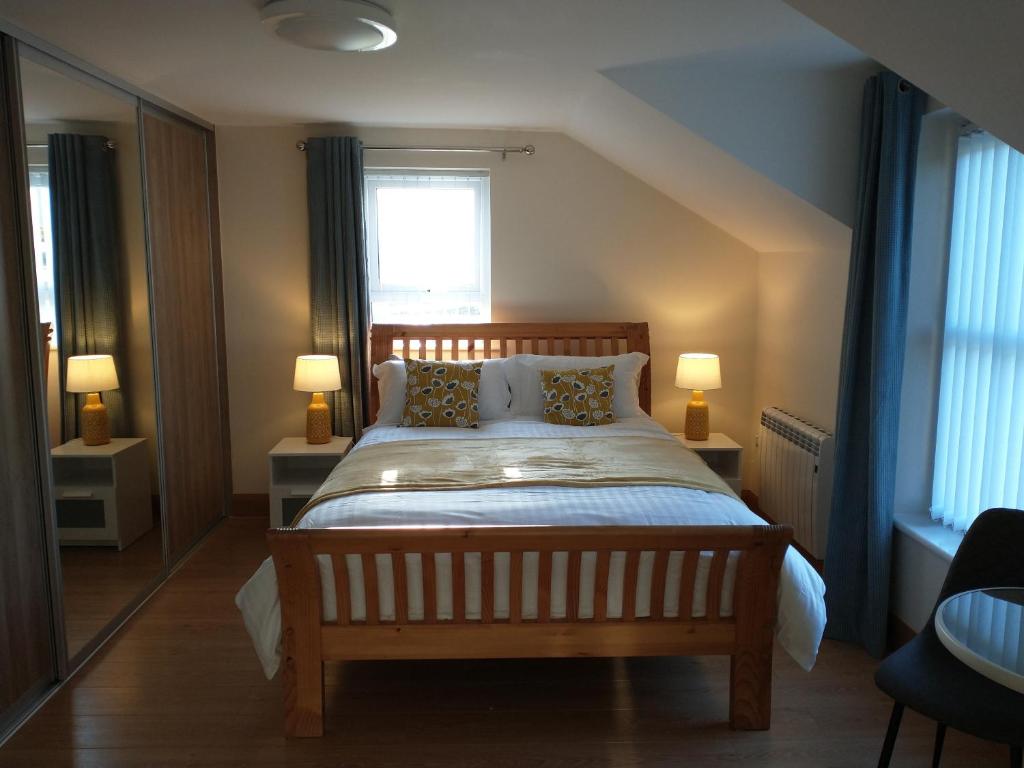 a bedroom with a bed with two lamps and a window at Woodview Bed & Breakfast in Kilkeel