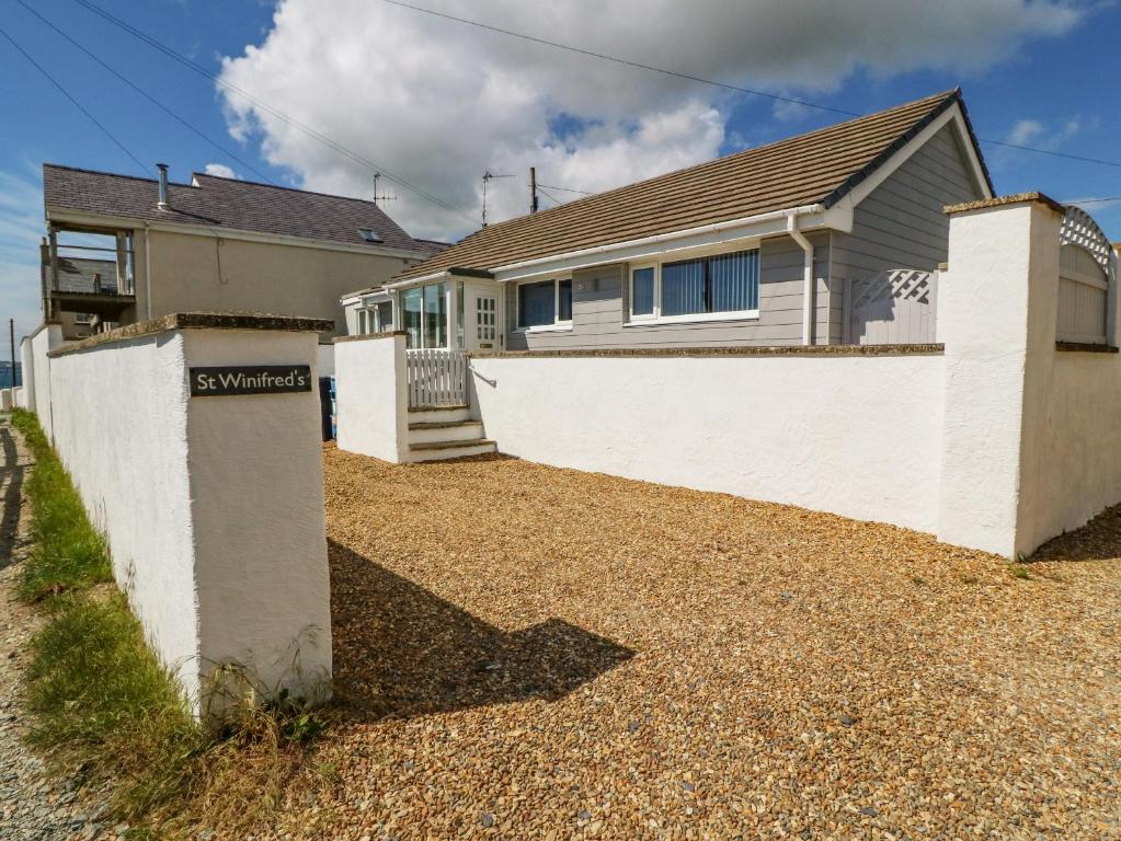 a house with a white fence in front of it at St Winifreds in Rhosneigr