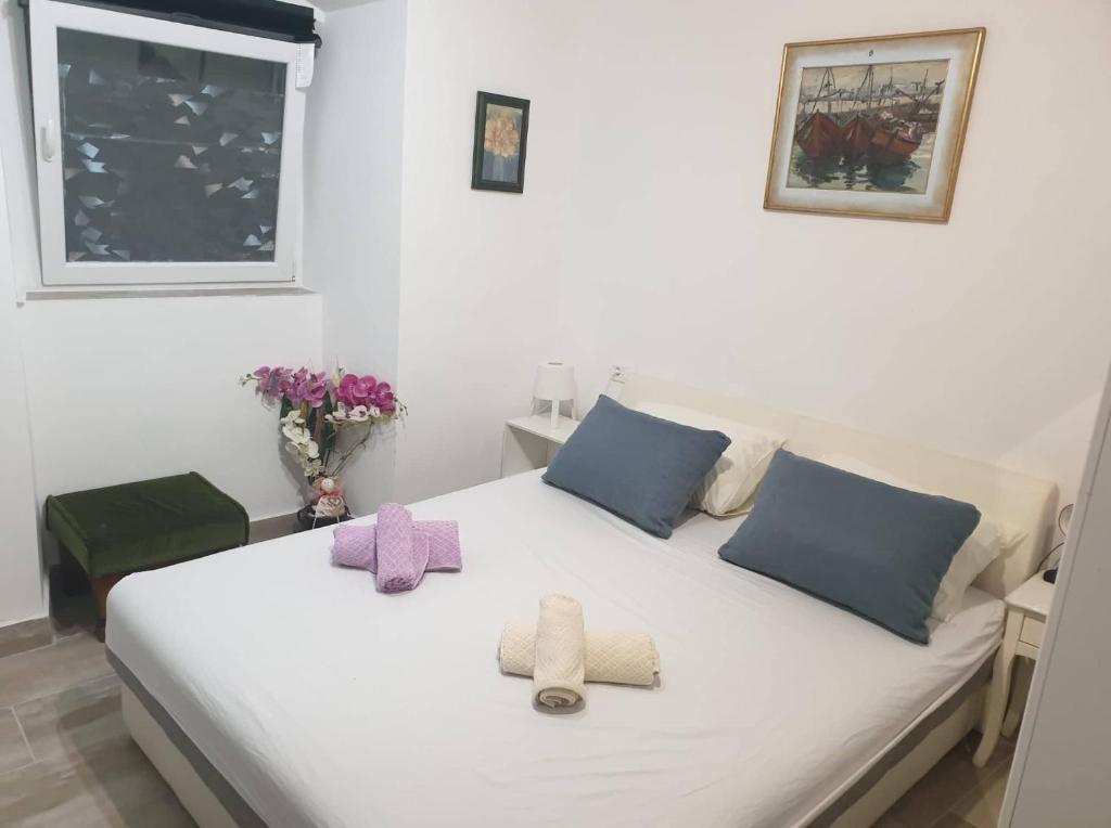 Un dormitorio con una cama blanca con toallas. en apartmani NEDO, en Split