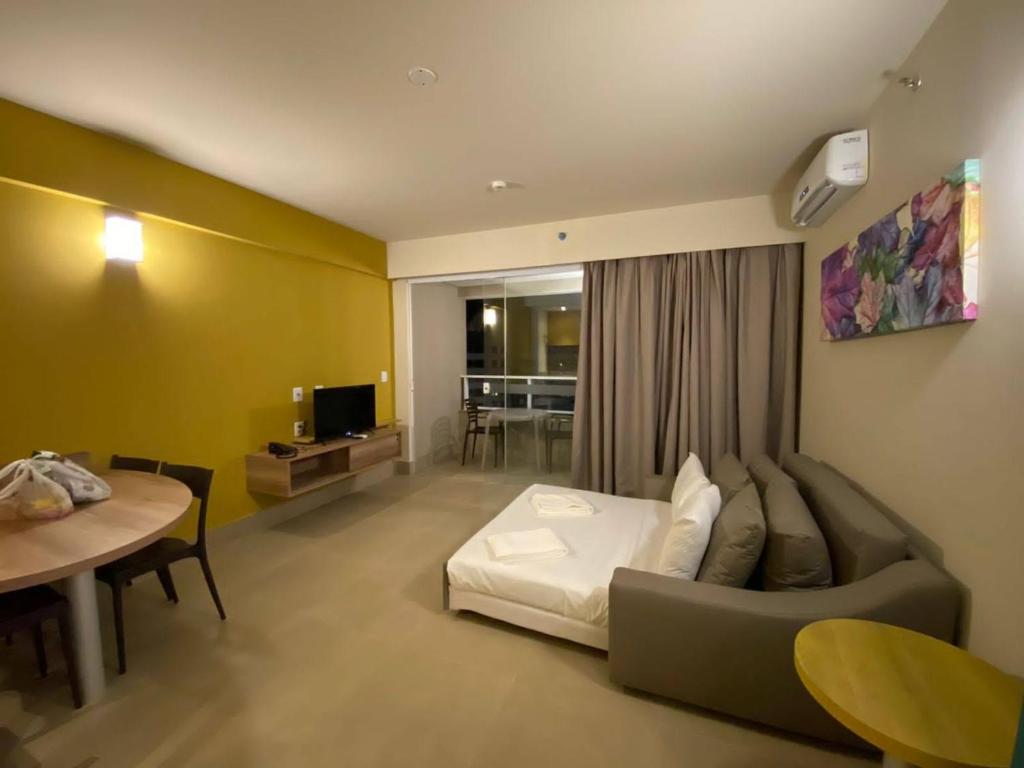 a room with a couch and a table and a television at Apartamento Resort Aguas Park Resort Olímpia in Olímpia