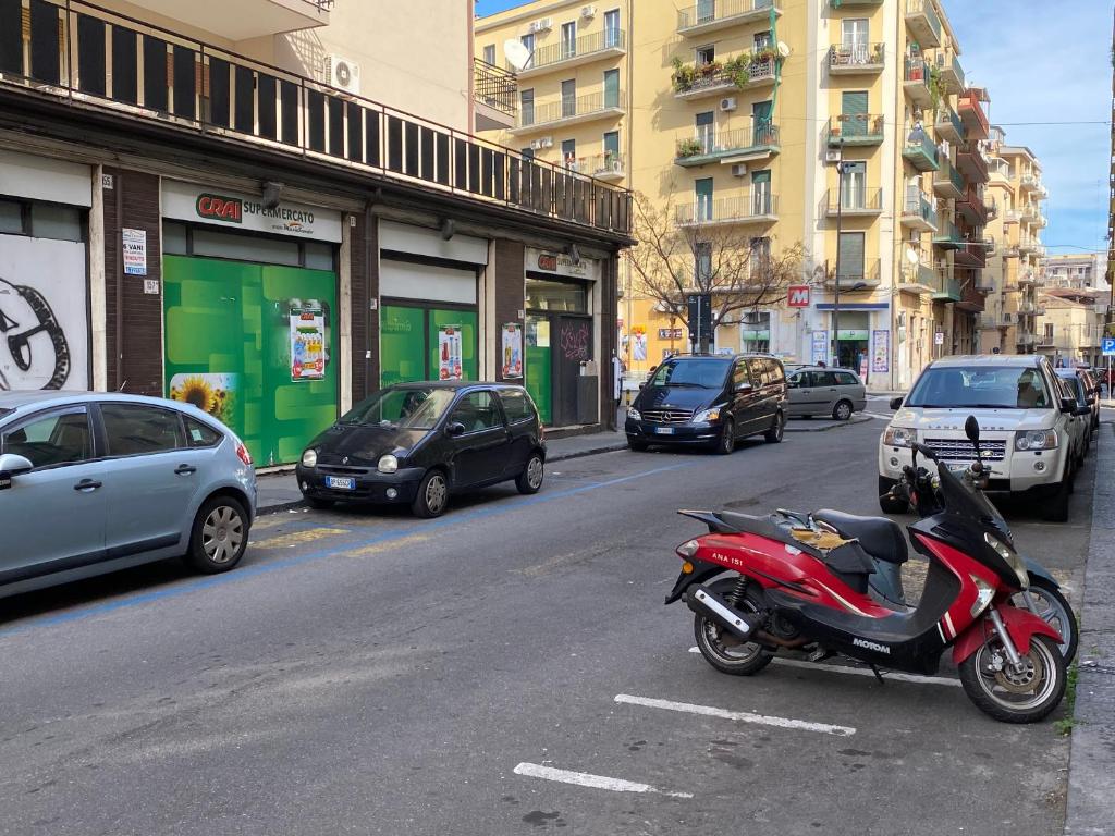 czerwony motocykl zaparkowany po stronie ulicy miejskiej w obiekcie Casa Catania w Katanii