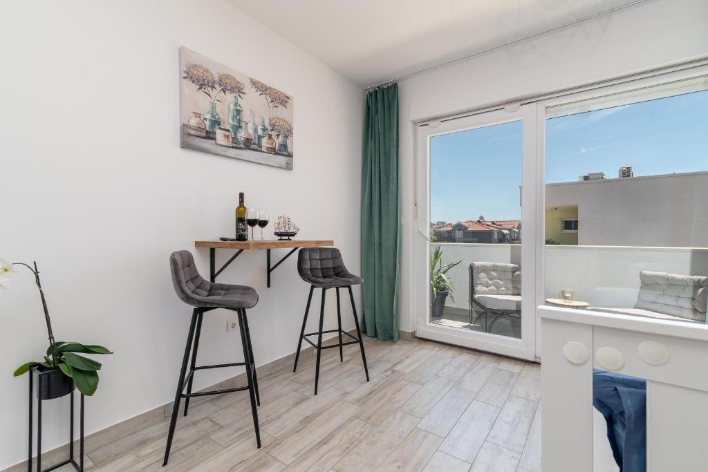 Sala de estar con mesa y 2 taburetes en Apartmani Princi Trogir, en Trogir