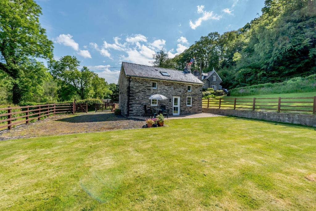 an old stone house with a large yard at Cwmdu Cottage in Cwm-coy