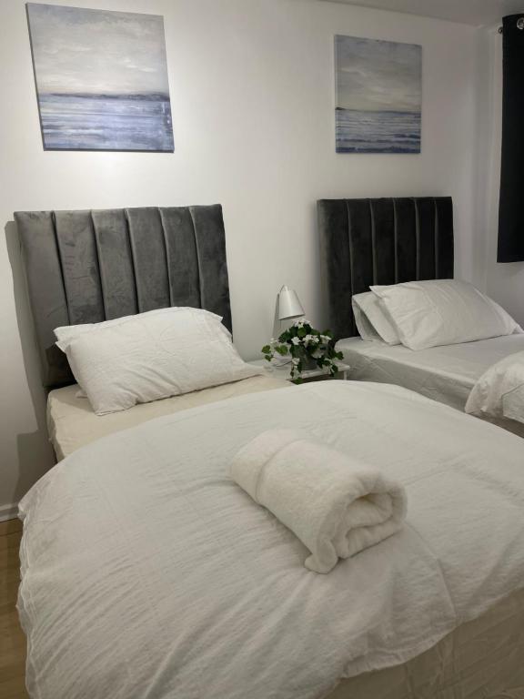 a bedroom with two beds with white sheets at NewSuites in London