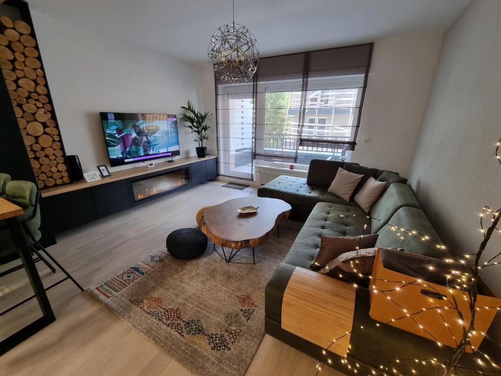 a living room with a couch and a table at Mountain Wings Bjelasnica Apartment in Bjelašnica