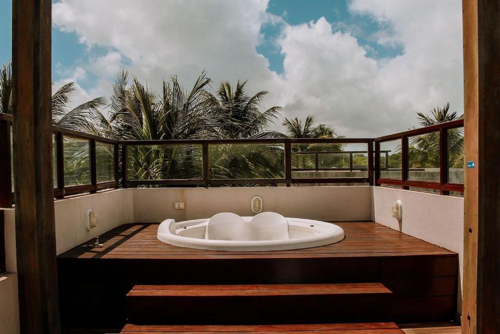 uma banheira sentada em cima de uma varanda em Qavi - Pipa Beleza Resort em Pipa