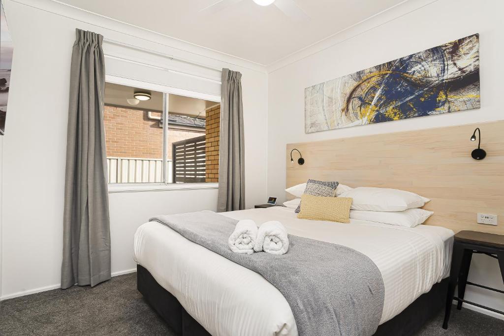 a bedroom with a bed with two towels on it at Adamstown Short Stay Apartments in Adamstown