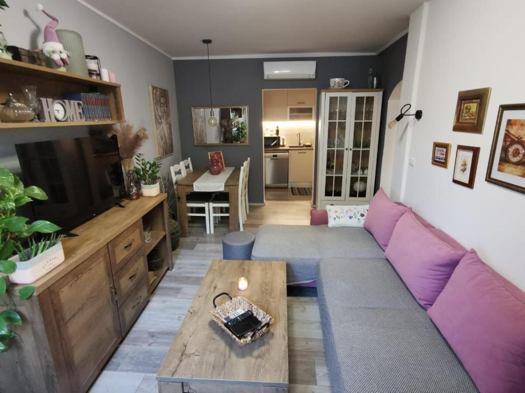 a living room with a purple couch and a table at Apartment with garden in Vela Luka