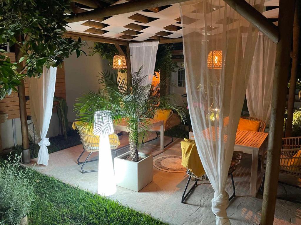 un patio con mesa y sillas bajo una pérgola en Elegant rooms, en Argostoli